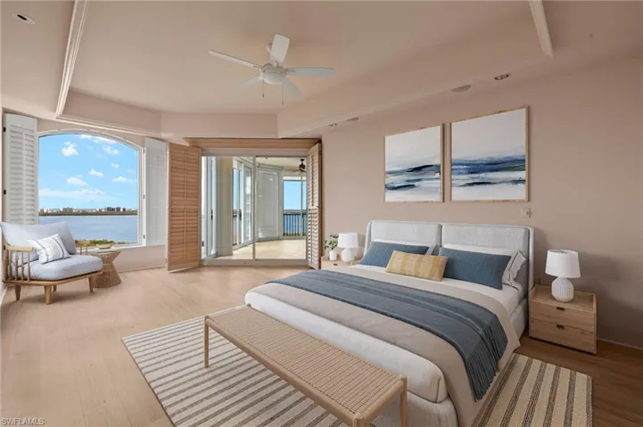 Virtually Staged. Bedroom featuring access to outside, multiple windows, a water view, and wood finished floors