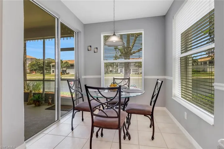 Tiled dining space featuring a water view and baseboards