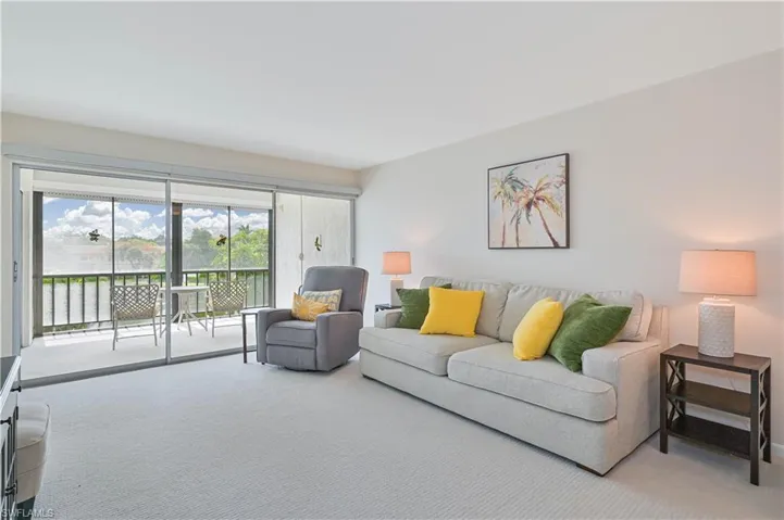 Expansive screened balcony featuring a railing overlooking a body of water and lush trees