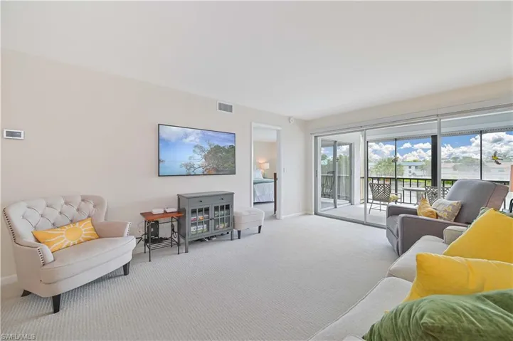 Spacious living area featuring light-toned carpeting and neutral wall tones