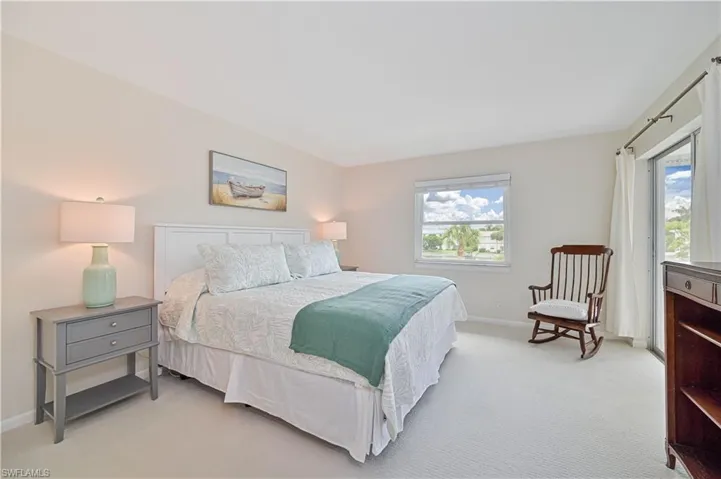Carpeted room featuring a window overlooking greenery and a sliding glass door