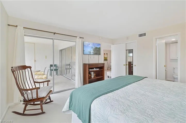 Room featuring light-colored carpet flooring and a sliding glass door