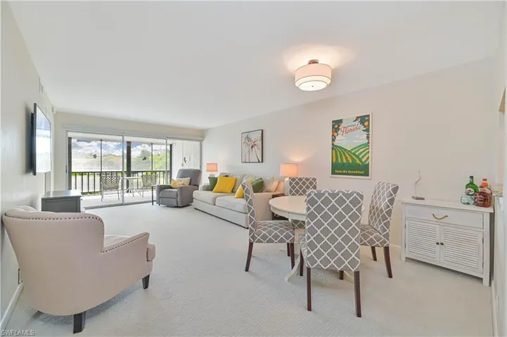 Open concept living and dining area featuring light-toned carpeting and neutral wall tones