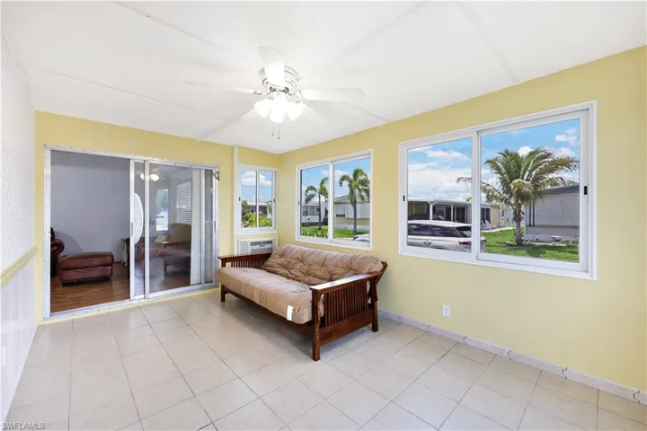 Sunroom with tile patterned floors and an AC wall unit