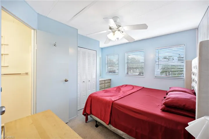 Bedroom featuring light carpet, ceiling fan, and a closet