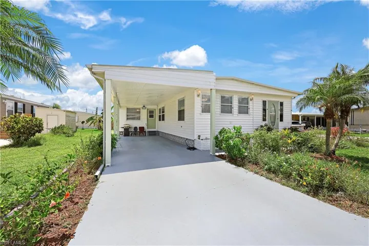 Manufactured / mobile home featuring driveway, a carport, and a patio