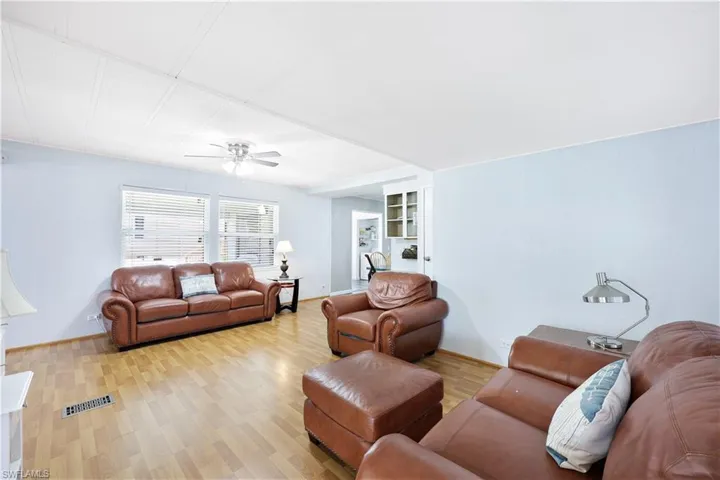 Living area featuring wood finished floors, a ceiling fan, and built in shelves