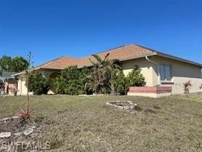 View of side of home featuring stucco siding and a yard