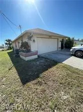 View of property exterior with an attached garage, concrete driveway, and a yard
