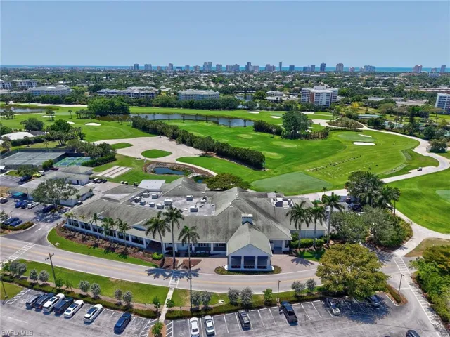 Drone / aerial view of a skyline view, a nearby body of water, and a golf club