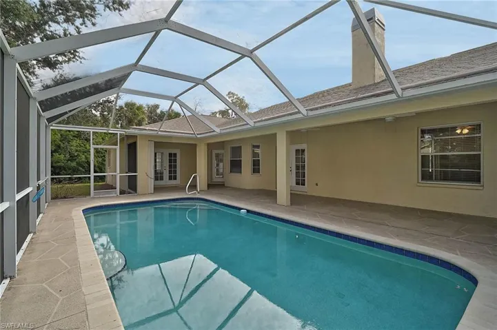 Outdoor pool with a lanai, french doors, and a patio area