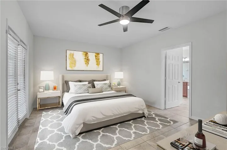 Bedroom featuring ceiling fan and light tile patterned floors and walkout to patio/Lanai