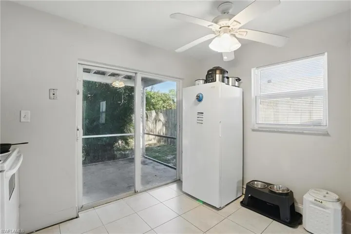 Entryway with light tile patterned floors and ceiling fan