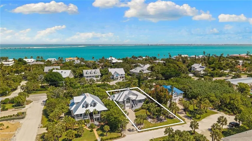 Aerial view of the property, showcasing its proximity to the ocean and surrounded by lush green trees