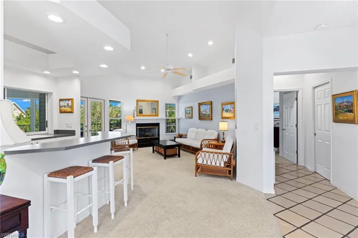 Open concept living area featuring vaulted ceilings, recessed lighting, and a fireplace with a mantel