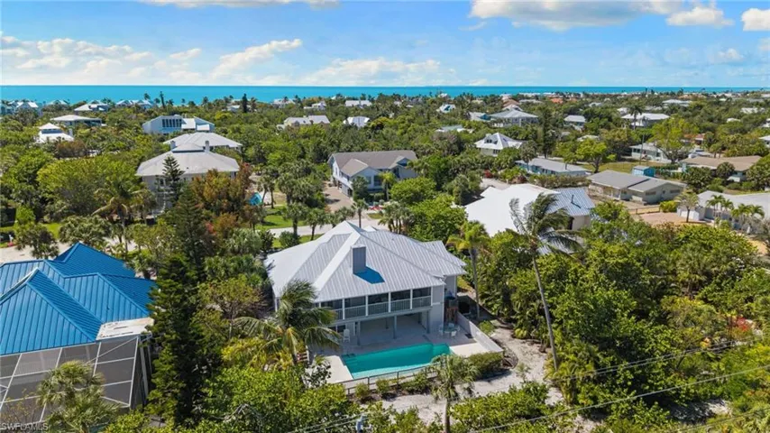 This property features a private swimming pool, a second-story balcony, and a light-colored metal roof