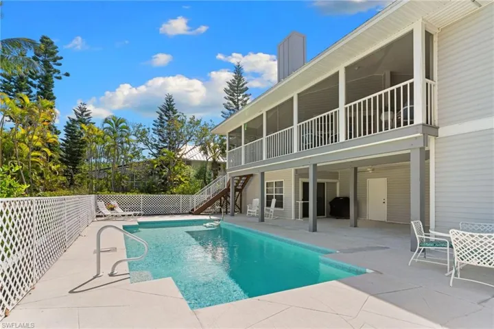The property features an outdoor swimming pool with surrounding patio space, a screened-in upper-level balcony, and a covered lower-level patio