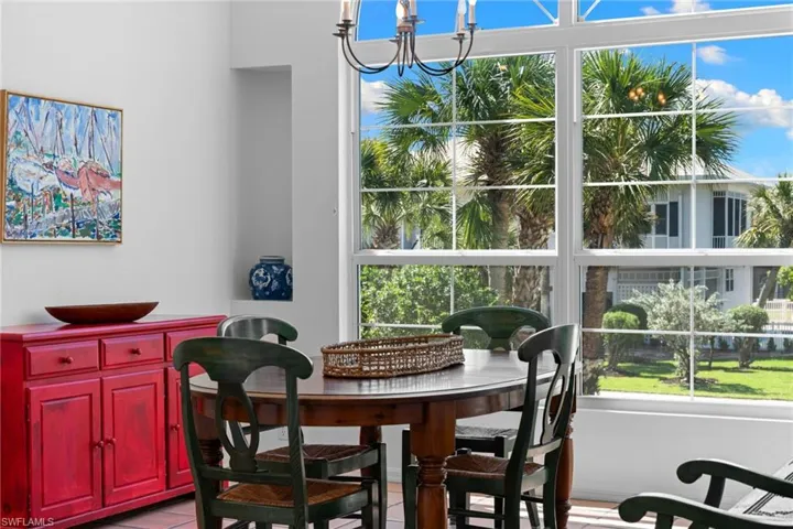 The property features large windows providing ample natural light and views of tropical trees and landscaping