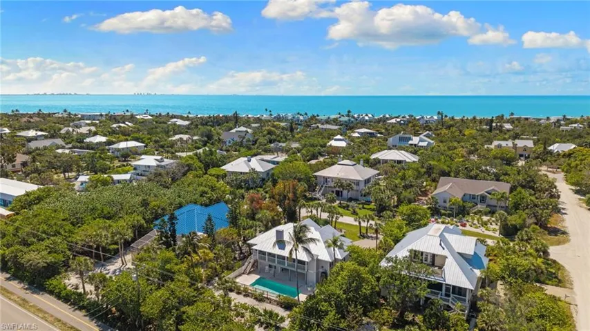 This aerial perspective highlights the property's location within a community of homes, all surrounded by lush green foliage
