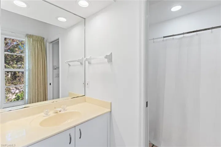 This bathroom features a spacious vanity with an integrated sink and an expansive mirror