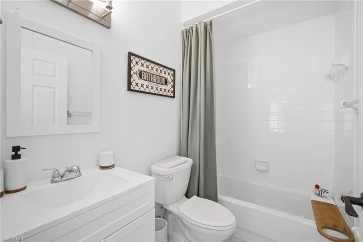 Full bath featuring vanity, shower / bath combination with curtain, and toilet
