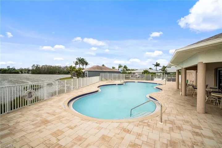 Community pool with a patio and fence