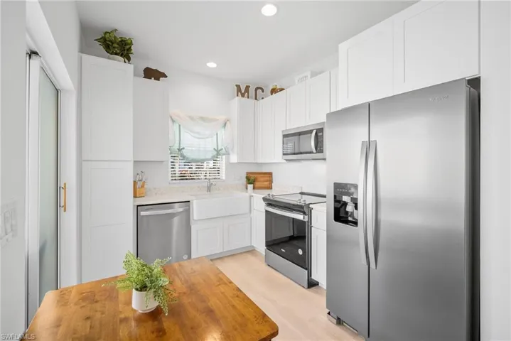 Kitchen featuring white cabinetry, stainless steel appliances, light countertops, and recessed lighting