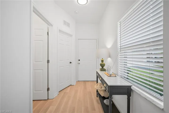 Hall with visible vents and light wood-style flooring