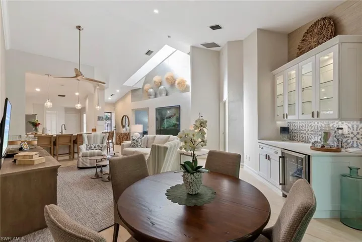 Dining room with wine cooler, high vaulted ceiling, and bar