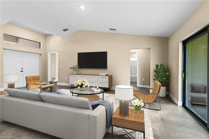 Living room with lofted ceiling and light tile patterned floors