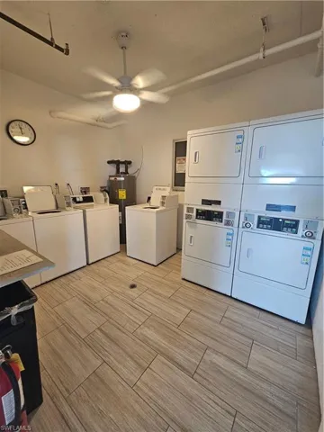 Shared laundry room featuring ceiling fan, washing machine and clothes dryer, and water heater