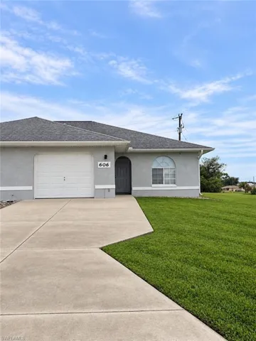 Gray stucco exterior with a dark gray entry door, arched entry, and an arched window