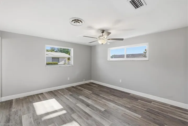 Master bedroom with light wood-style floors, a ceiling fan, and plenty of natural light