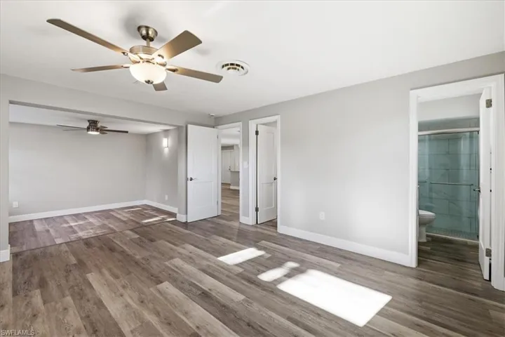 Master  bedroom featuring dark wood finished floors, ceiling fan, and connected bathroom