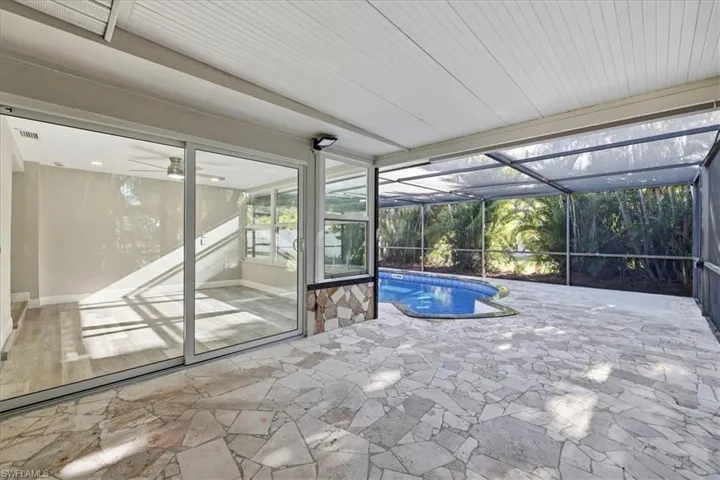 old Outdoor pool with a sunroom, a lanai, and a patio area
