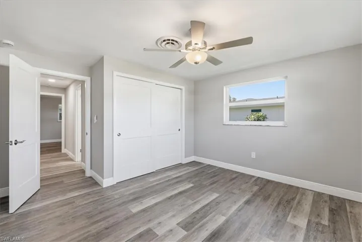 Unfurnished bedroom featuring light wood-type flooring, a closet, and a ceiling fan