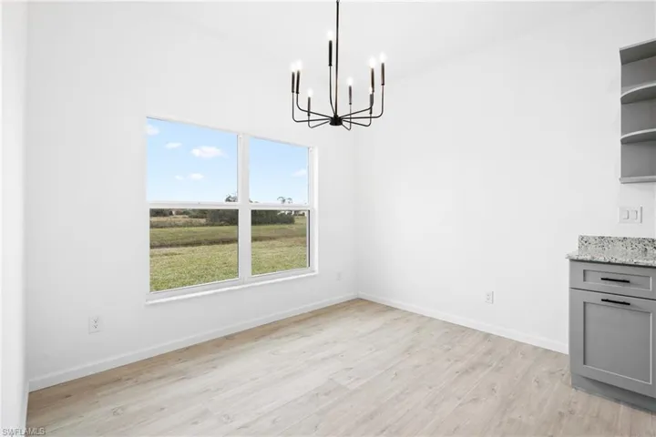 Unfurnished dining area with light hardwood / wood-style flooring and an inviting chandelier