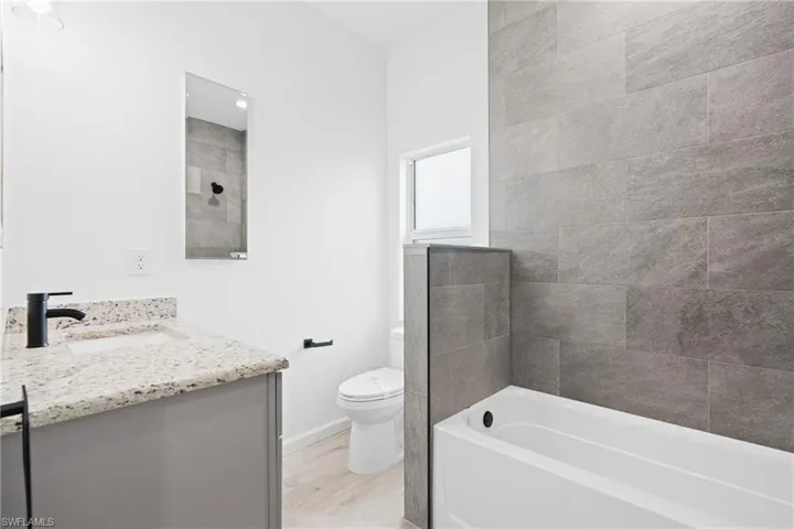 Bathroom with toilet, vanity, and wood-type flooring