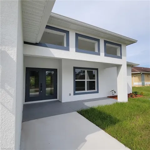 Entrance to property with a yard and a patio area