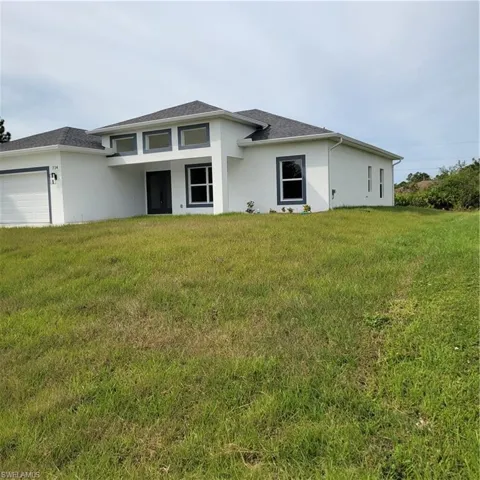 View of front of home with a front yard and a garage