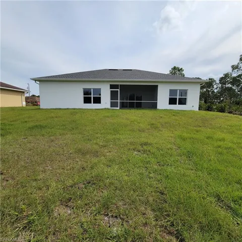Back of house with a lawn