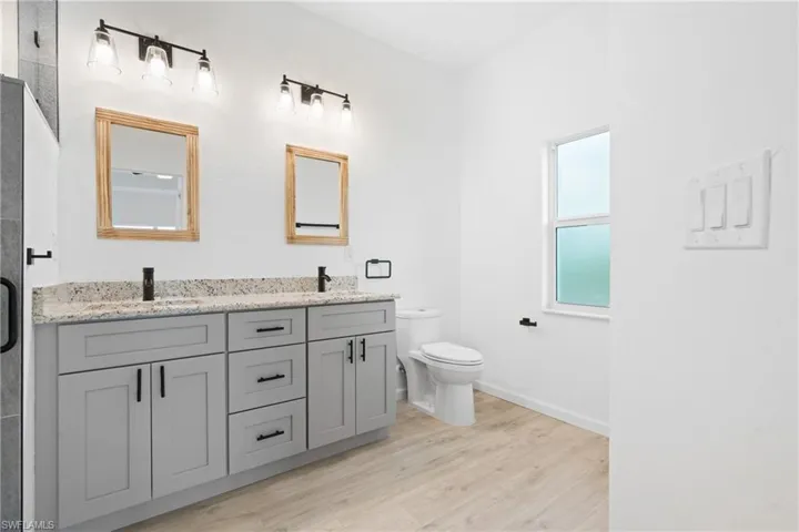 Bathroom with hardwood / wood-style floors, vanity, and toilet