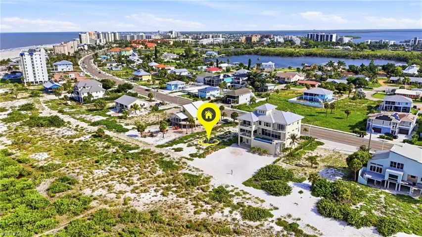 Aerial perspective showcasing a coastal community with prominent beach frontage - Virtually Edited Image