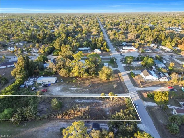 Aerial view of residential area featuring a heavily wooded area and property boundaries highlighted