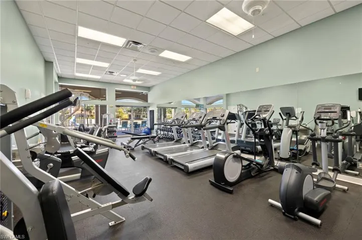 Exercise room featuring a paneled ceiling and a high ceiling