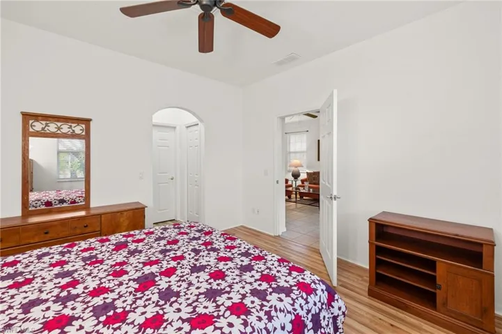 Bedroom with multiple windows, ceiling fan, and light hardwood / wood-style flooring
