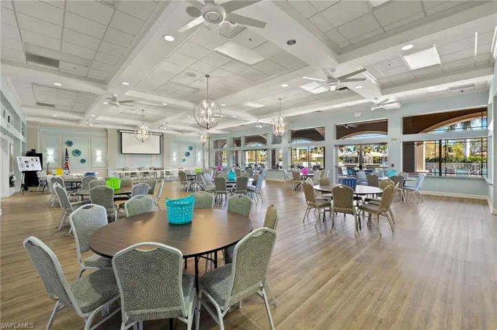 Dining room featuring plenty of natural light, coffered ceiling, and ceiling fan with notable chandelier