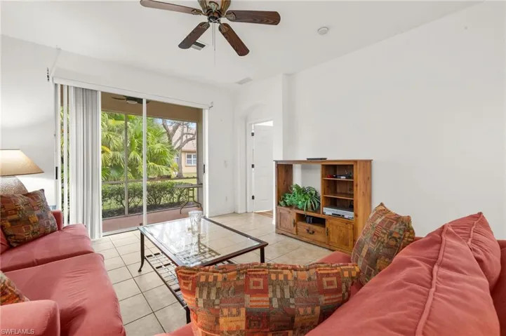 Living room featuring light tile patterned flooring and ceiling fan