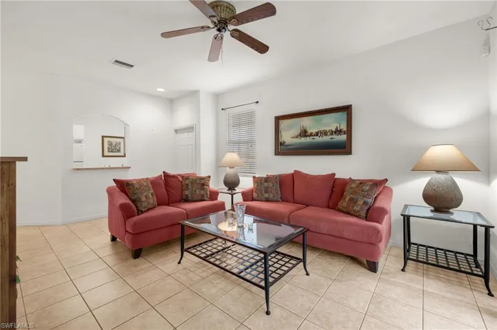 Living room with light tile patterned floors and ceiling fan