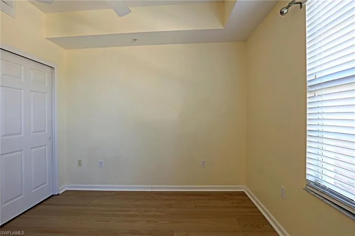 Unfurnished bedroom with wood finished floors, a ceiling fan, and a closet